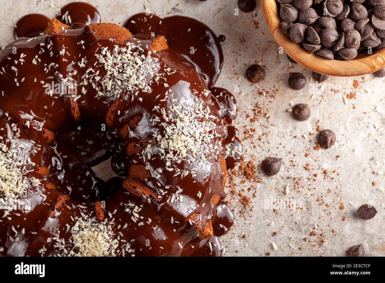 Flaches Lay-Bild von einem Schokoladenkuchen mit geschmolzenem Pudding-Eis und Schokoladenstückchen in einer Schüssel im Hintergrund. Die Dekoration dieser leckeren Kuchen w Stockfoto