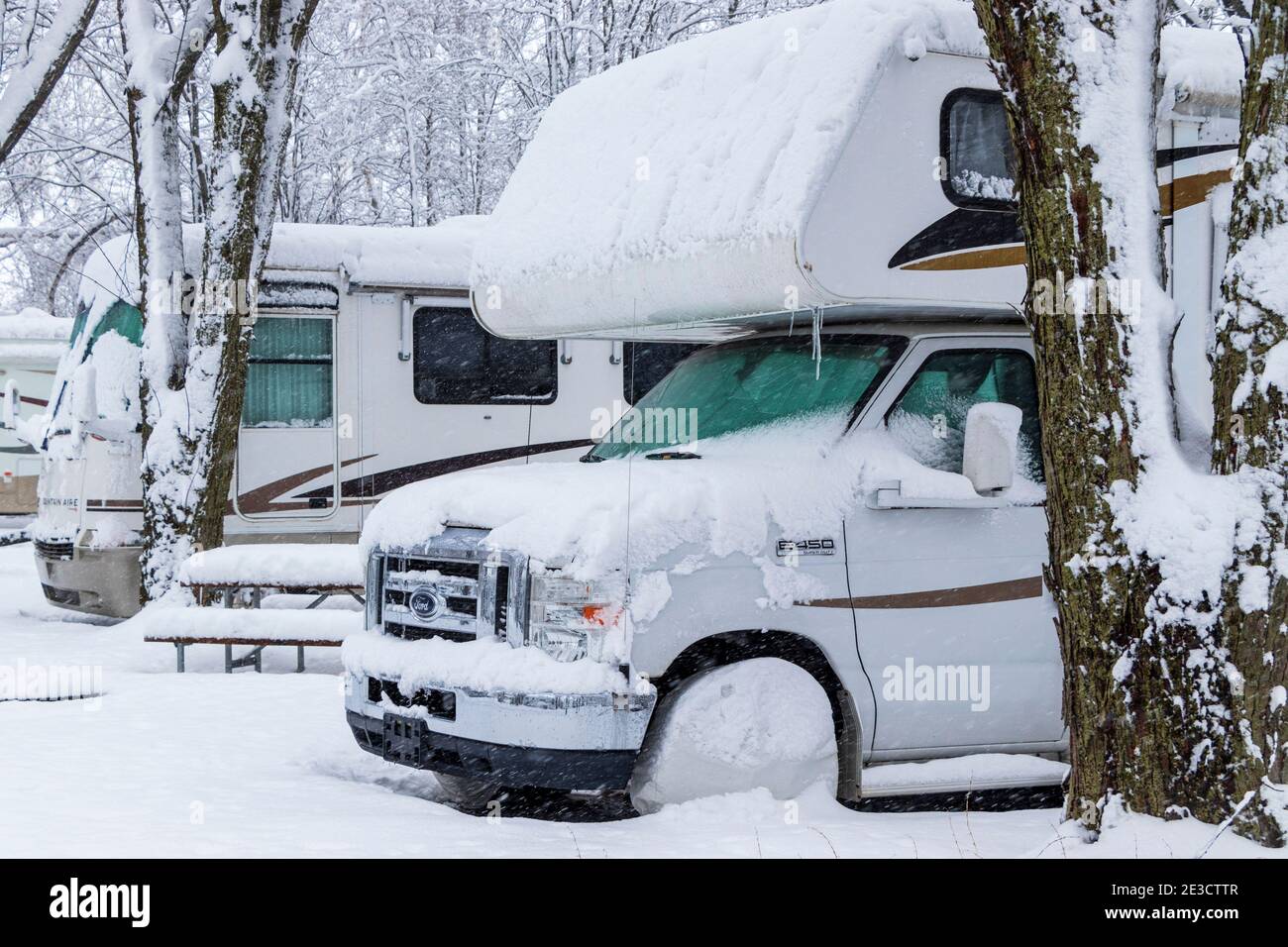 17. Januar 2021 - Roxton Falls, QC, Kanada: RVS in einer Reihe auf Campingplätzen geparkt, während Schneesturm, winterfest, Lagerung für die Wintersaison Stockfoto