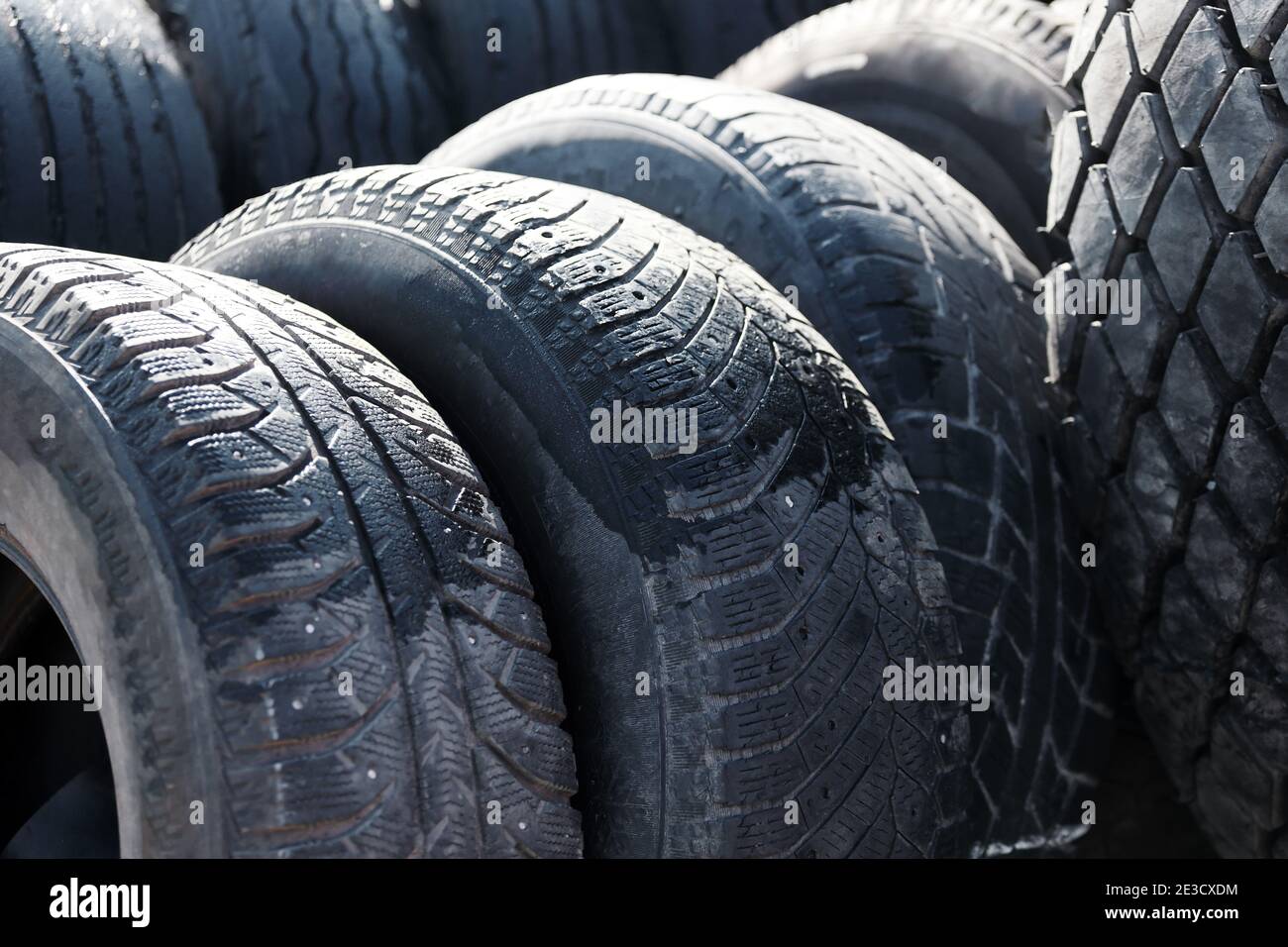 Recycling von Autoreifen für LKW. Das sind viele schwarze Glatzenreifen, die draußen in einem offenen Lager liegen. Stockfoto