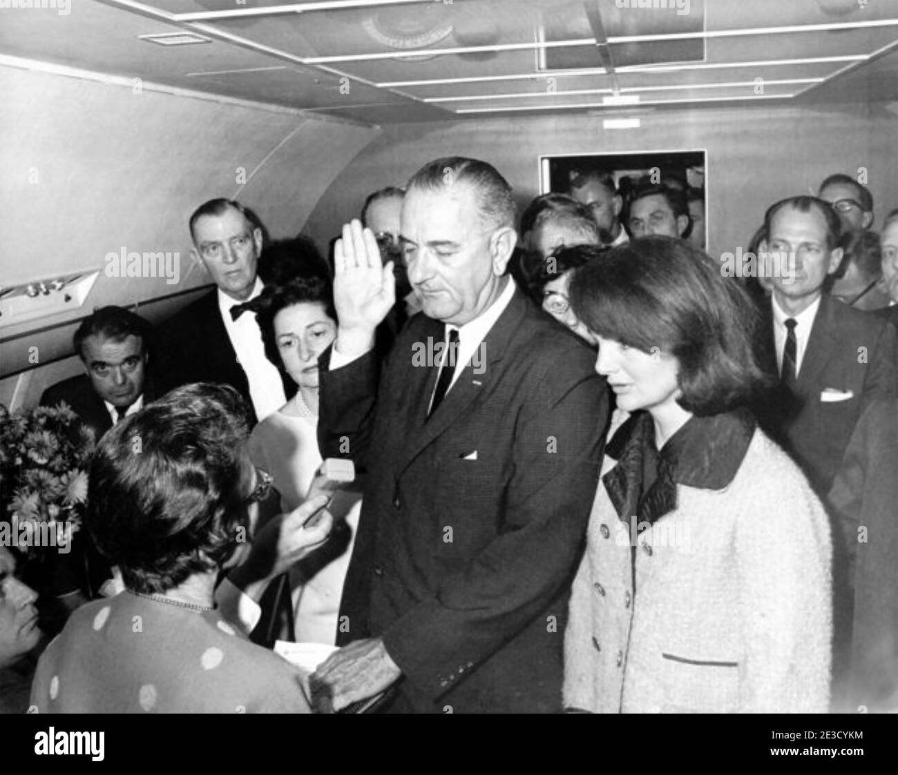 LYNDON JOHNSON legt den Amtseid an Bord der Air Force One am Love Field Airport, Dallas, Texas, ab, zwei Stunden nach der Ermordung von Präsident John F. Kennedy am 22. November 1963. Seine Frau, jetzt First Lady Bird Johnson zu seiner Rechten und Jacqueline Kennedy zu seiner Linken. Stockfoto