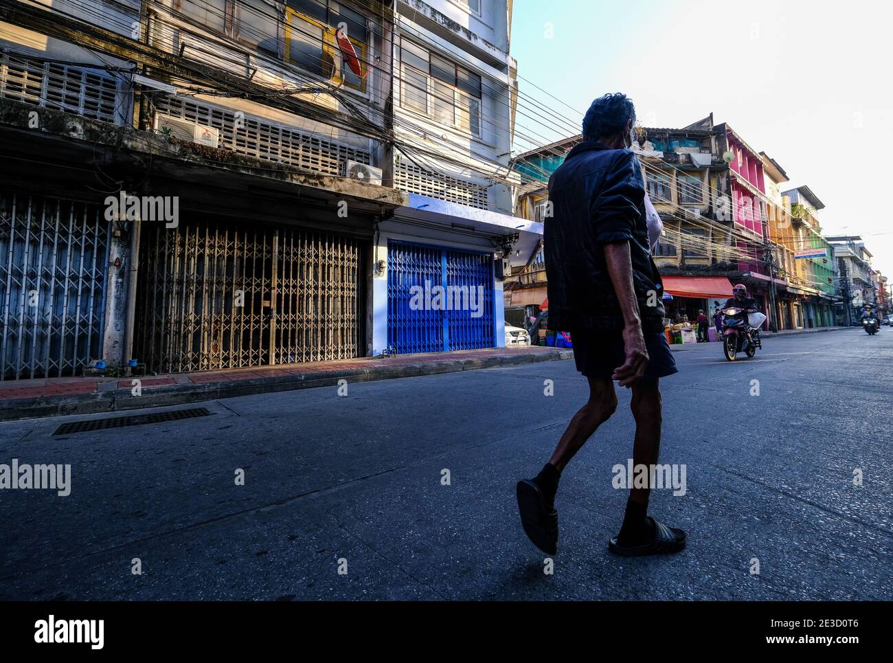 Ein Mann überquert eine Straße in Chinatown, Bangkok, Thailand Stockfoto