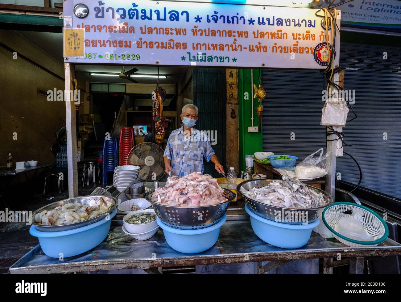 Ein Restaurantbesitzer steht hinter seinem Stand in Chinatown, Bangkok, Thailand Stockfoto