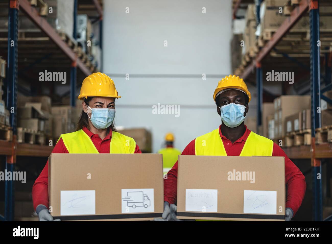 Das Team arbeitet im Lager und lädt die Lieferkisten mit dem Gesicht Chirurgische Maske während Corona Virus Pandemie - Logistik und Industrie Konzept Stockfoto