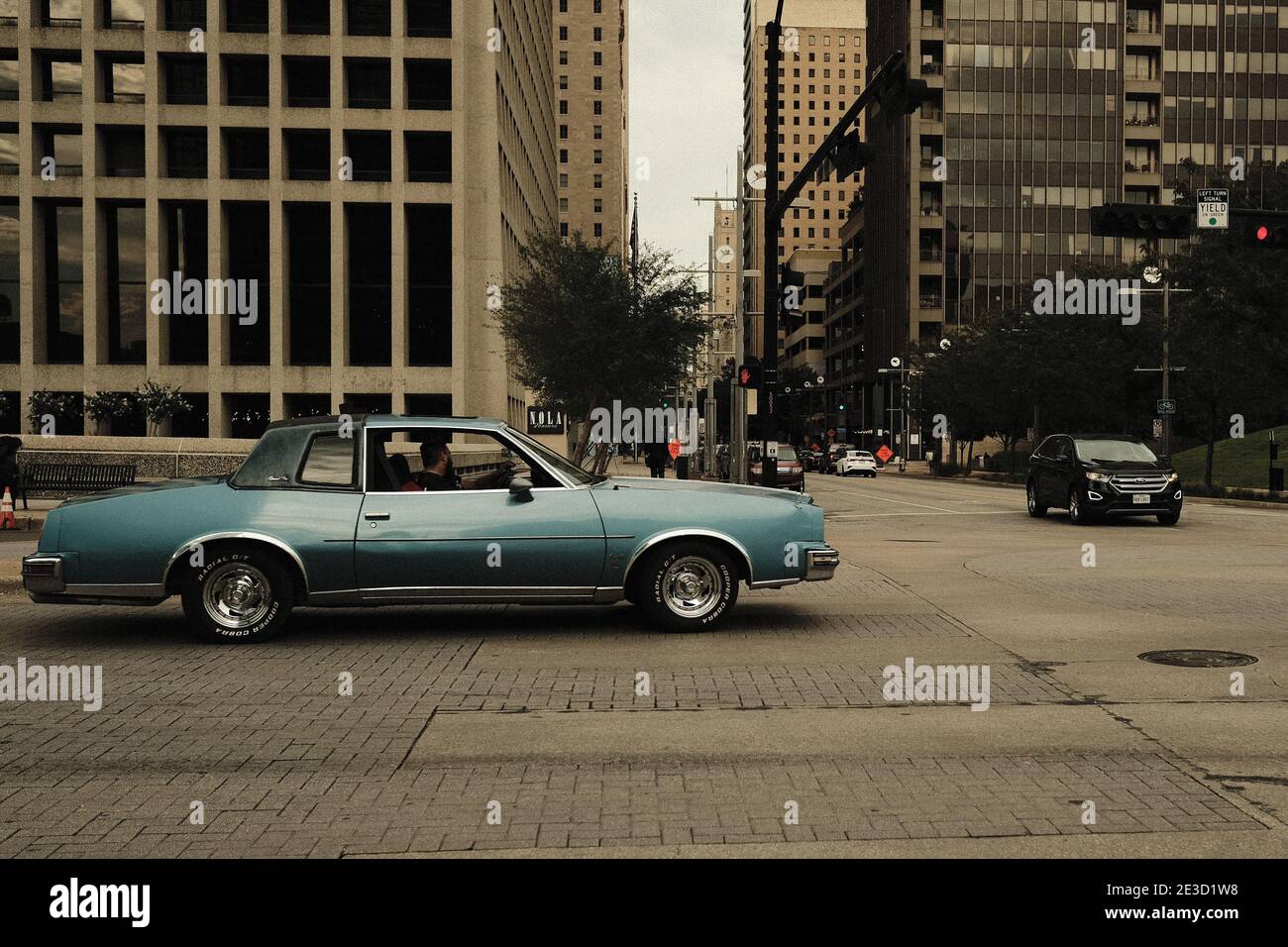 Blauer klassischer Cabriolet, der durch eine Kreuzung in der Innenstadt fährt Dallas Stockfoto