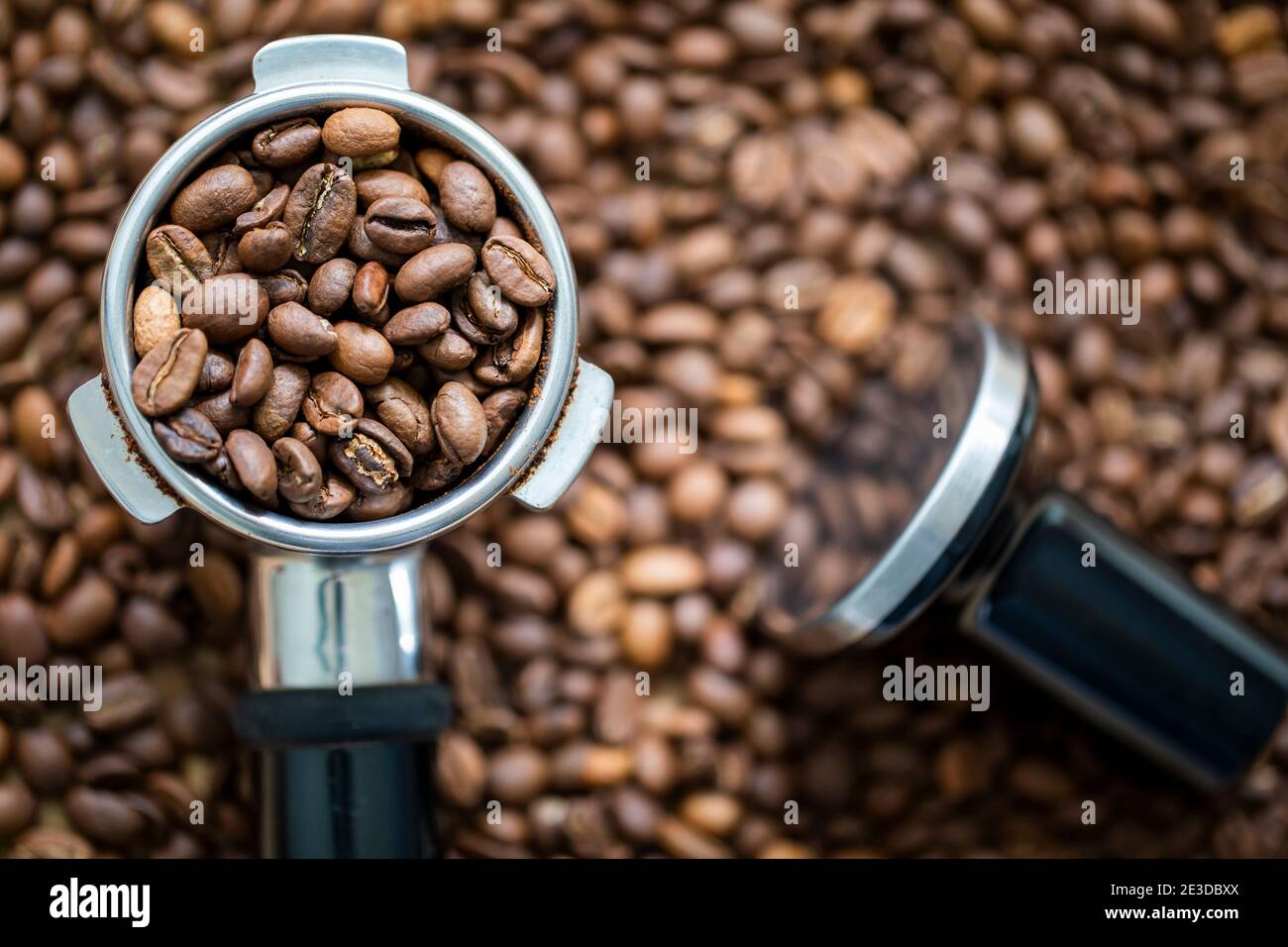 Kaffeebohnen in einem Portafilter, bereit, zu einem heißen Espresso zuzubereiten Stockfoto