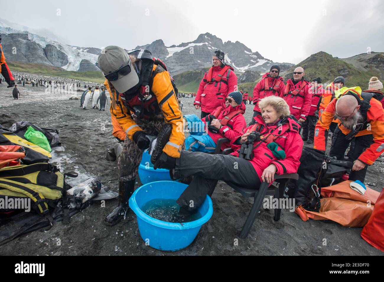 Touristen, die die Gold Harbour Bay in der südlichen geogia-Insel Antarktis besuchen, putzen Stiefel, bevor sie das Land verlassen. Teil von Maßnahmen zur Biosicherheit Stockfoto