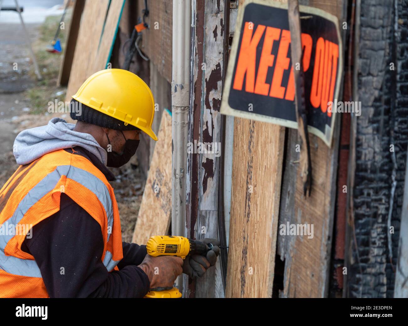 Detroit, Michigan, USA. Januar 2021. Freiwillige besteigen ein ausgebranntes Haus als Teil eines Tages des Gemeindedienstes auf dem Martin Luther King Jr. Feiertag. Kredit: Jim West/Alamy Live Nachrichten Stockfoto