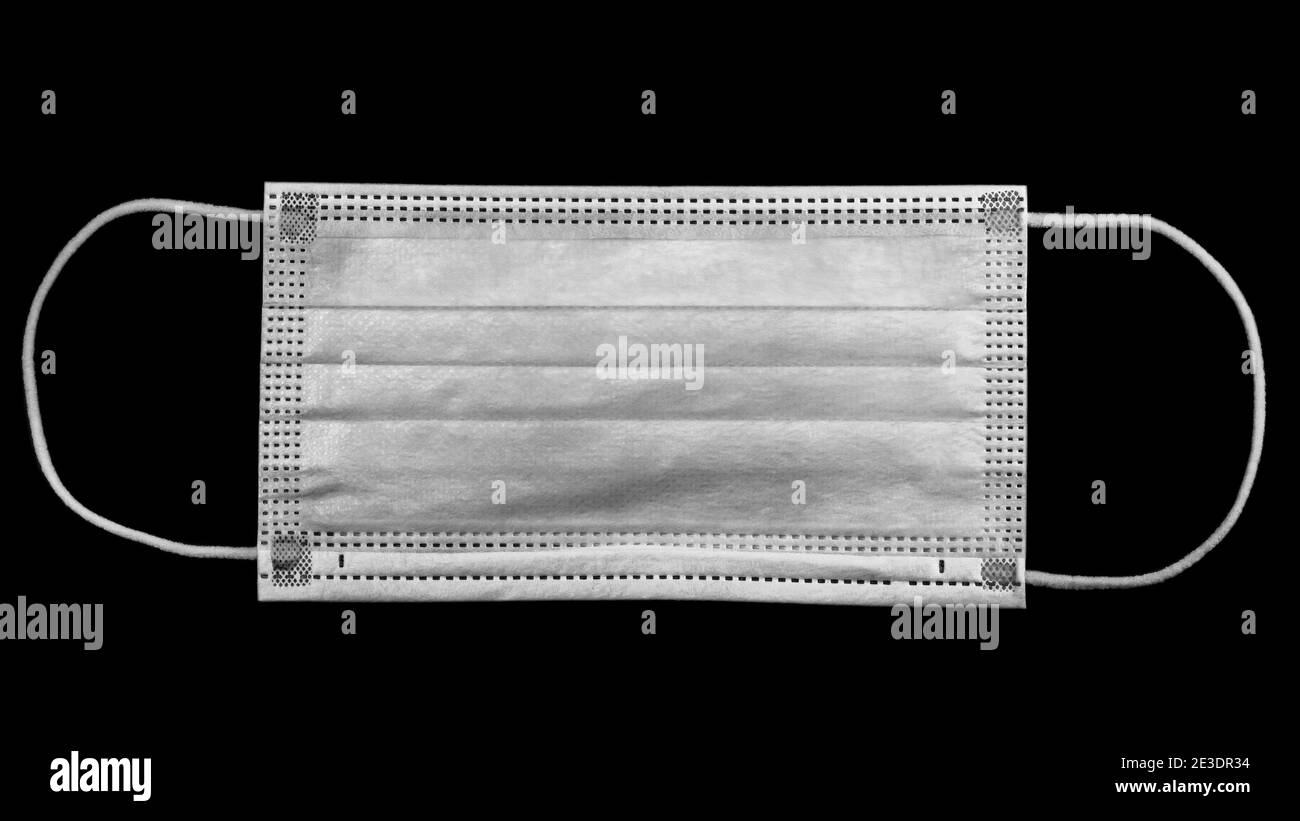 Chirurgische Maske auf schwarzem Hintergrund Stockfoto