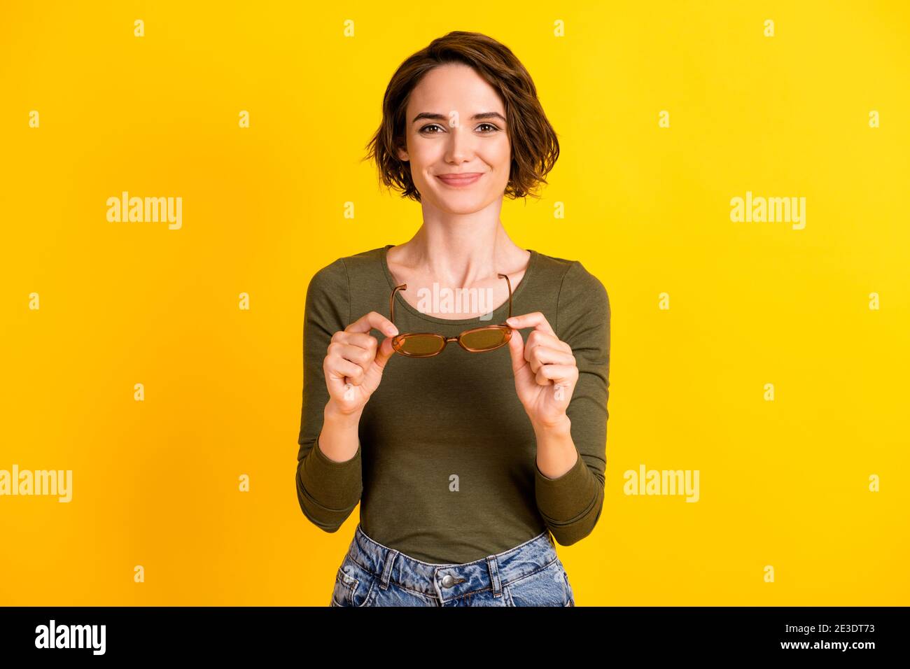 Foto von ziemlich junge Dame nehmen aus halten Brillen tragen Sonnenglas grün Hemd isoliert lebendige gelbe Farbe Hintergrund Stockfoto