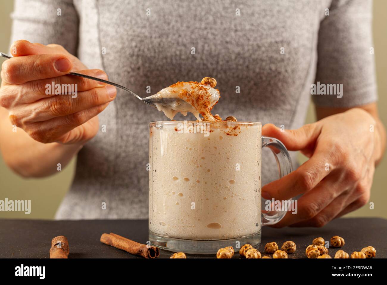 Eine Frau isst traditionelle Viskose türkischen fermentierten Getränk namens Boza. Es wird mit Zimt und gerösteten Kichererbsen serviert, ein Klassiker für Winter m Stockfoto