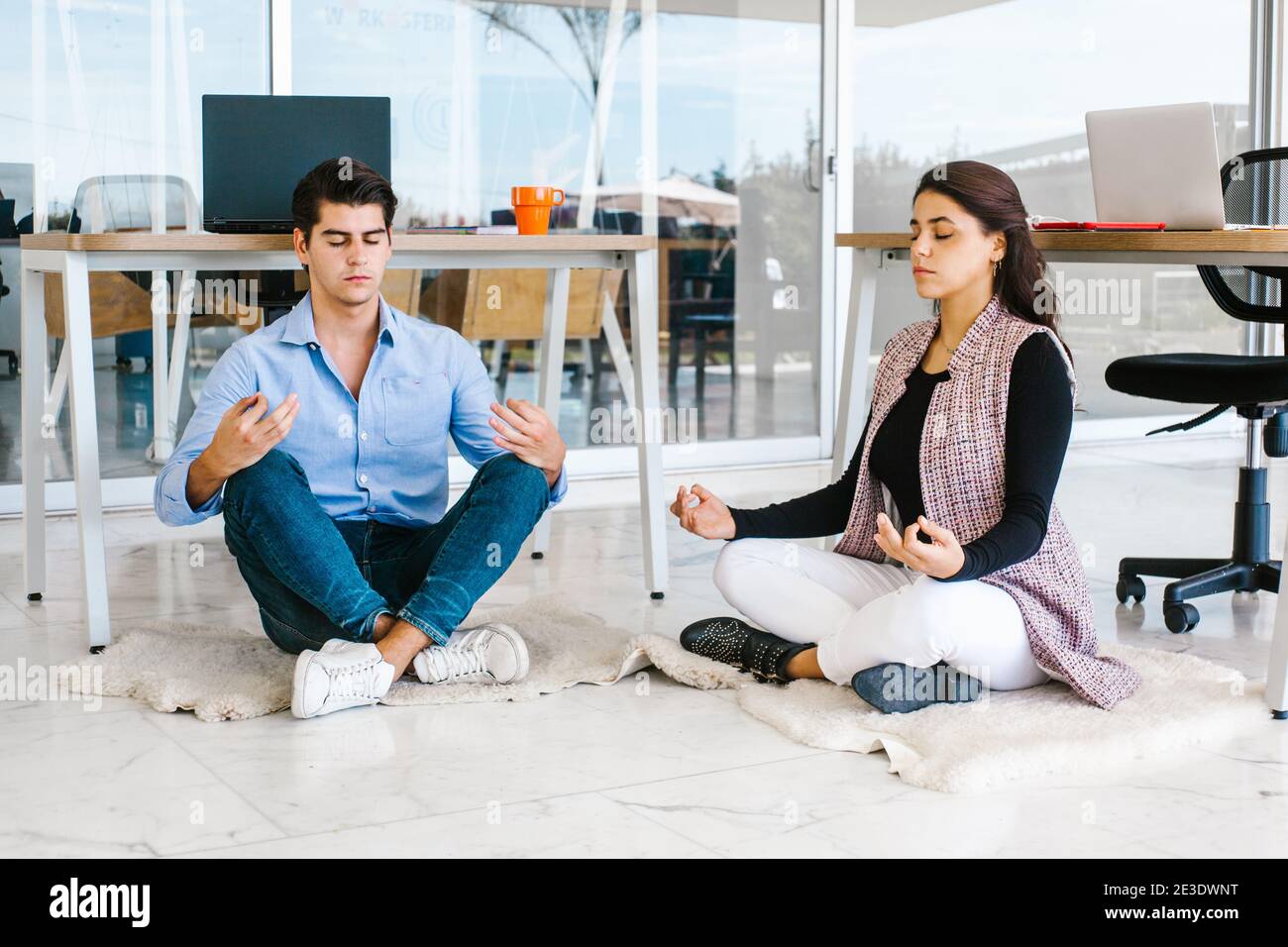 latin Geschäftsleute meditieren und Yoga im Büro in Mexiko-Stadt Stockfoto