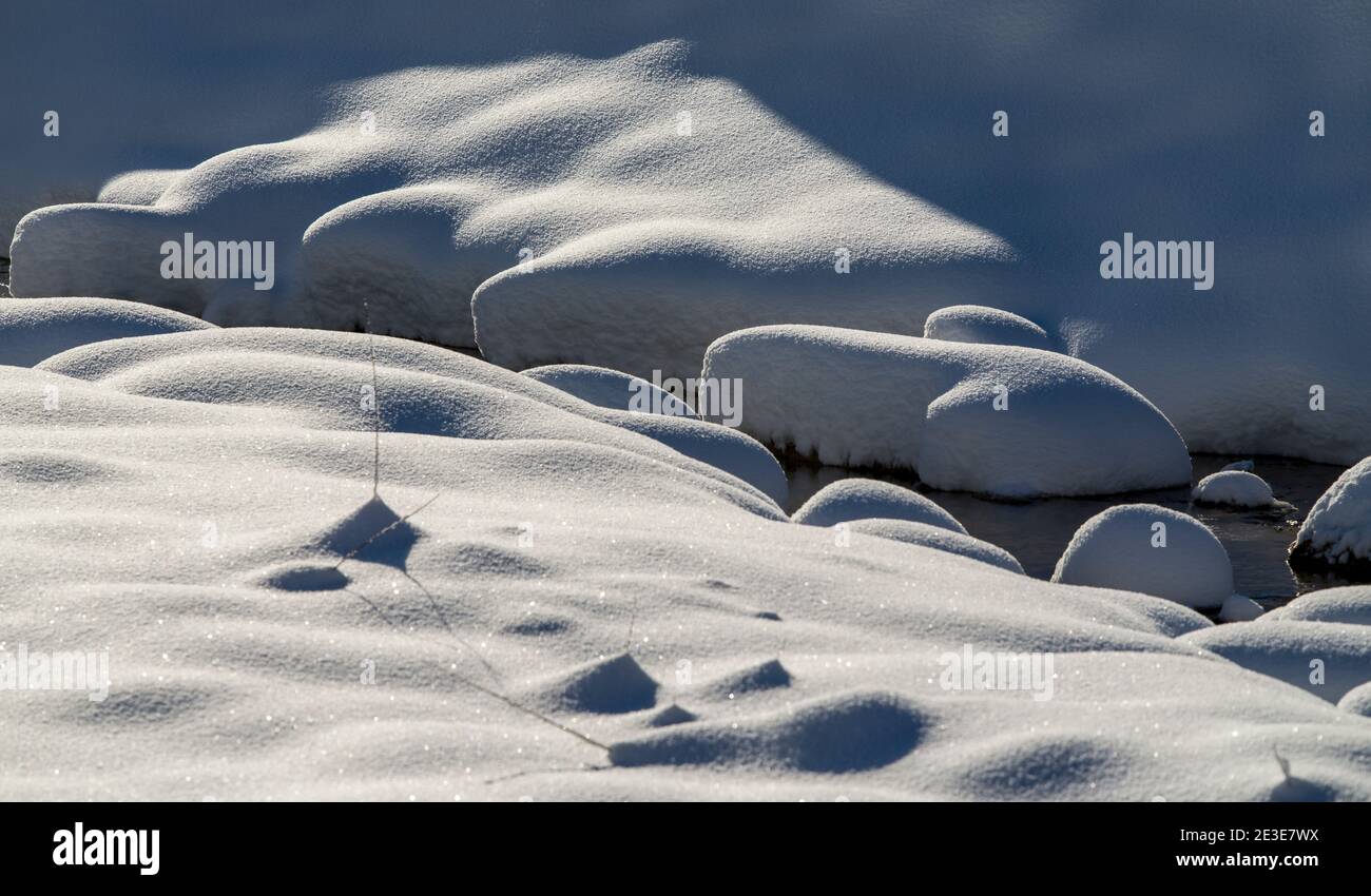 Abstrakte Kunst der Natur - schneebedeckte Steine im Fluss Stockfoto