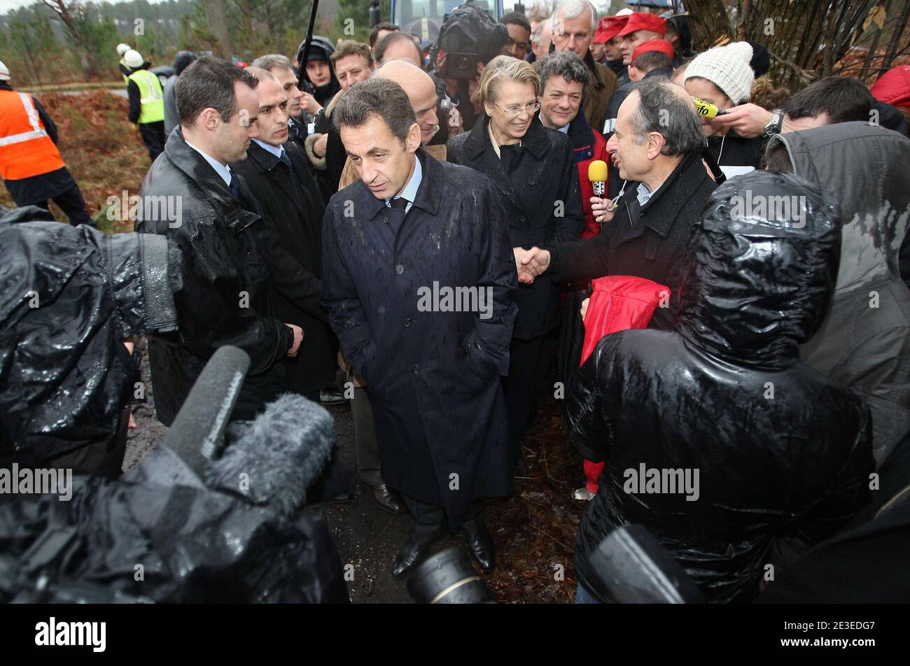 Der französische Präsident Nicolas Sarkozy, Minister für Ökologie, Energie und nachhaltige Planung und Entwicklung Jean-Louis Borloo und Innenminister Michele Alliot-Marie im Gespräch mit dem Rettungshelfer während eines Besuchs in Le Pian-Medoc, Südwestfrankreich, am 25. Januar 2009, um Schäden zu untersuchen, die durch den Sturm am Samstag verursacht wurden, Das schlimmste, das Frankreich seit einem Jahr 1999 getroffen hat, das Dutzende tötete und Millionen von Bäumen entwurzelte. Geschwader von Technikern aus ganz Europa kämpften Today, um Frankreichs Strom- und Schienennetze wieder auf Kurs zu bringen, nachdem Hurrikan-Stürme im Südwesten verheerende Schäden angerichtet hatten und vier dea hinterließen Stockfoto