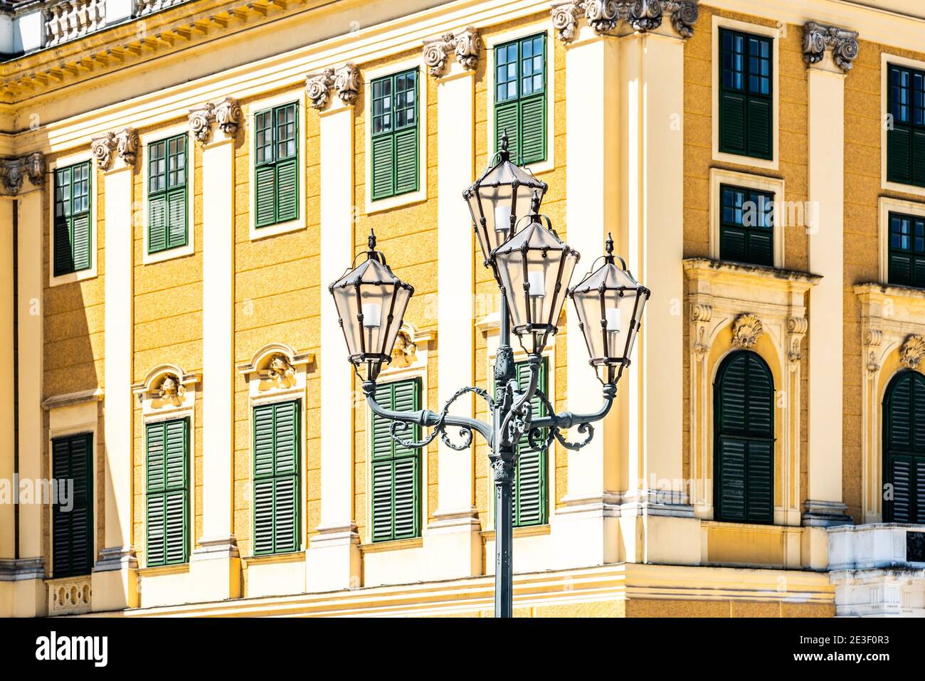 WIEN, ÖSTERREICH - 23. JULI 2019: Schloss Schönbrunn, Deutsch: Schloss Schönbrun, barocke Sommerresidenz der Habsburger Monarchen in Hietzing, Wien, Österreich. Detaillierte Ansicht der Fassade und dekorative Straßenlaterne. Stockfoto