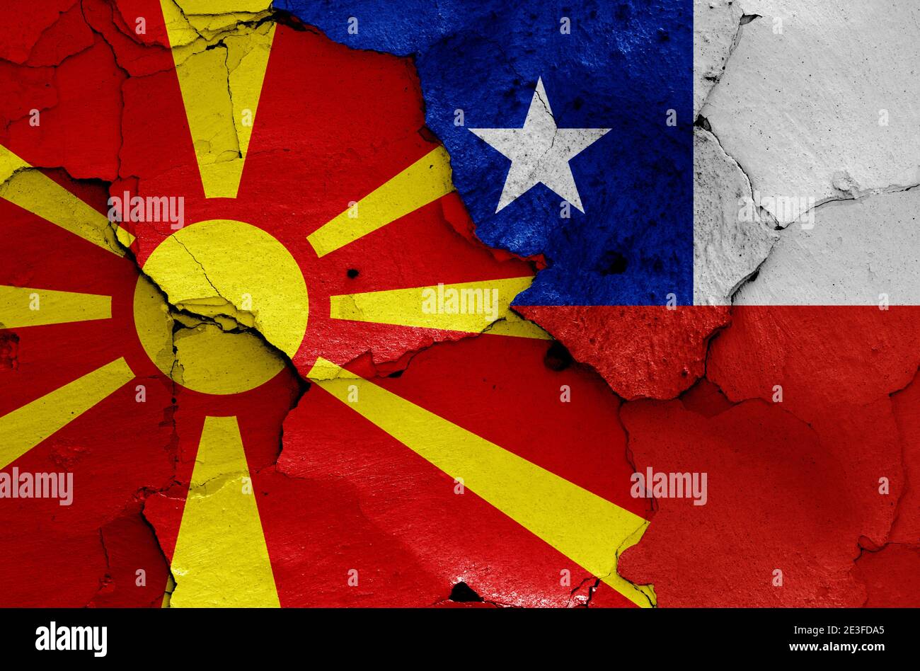 Flaggen von Nord-Mazedonien und Chile auf rissige Wand gemalt Stockfoto