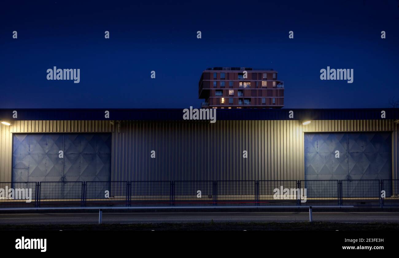 Lagerhaus vor dem Apartmentgebäude.Foto in der frühen Nacht aufgenommen. Die Lichter in den Apartments begannen gerade zu leuchten Stockfoto