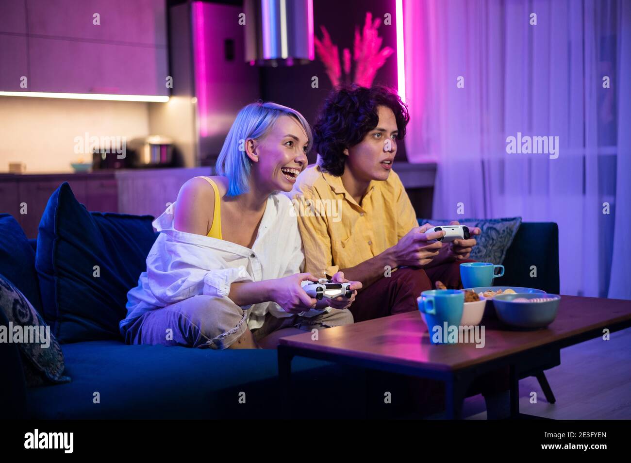 Hübscher junger Mann beizubringen, wie man die Videospiele zu seiner Freundin auf der Couch, Konzept über home-Entertainment, Videospiele zu spielen. Stockfoto