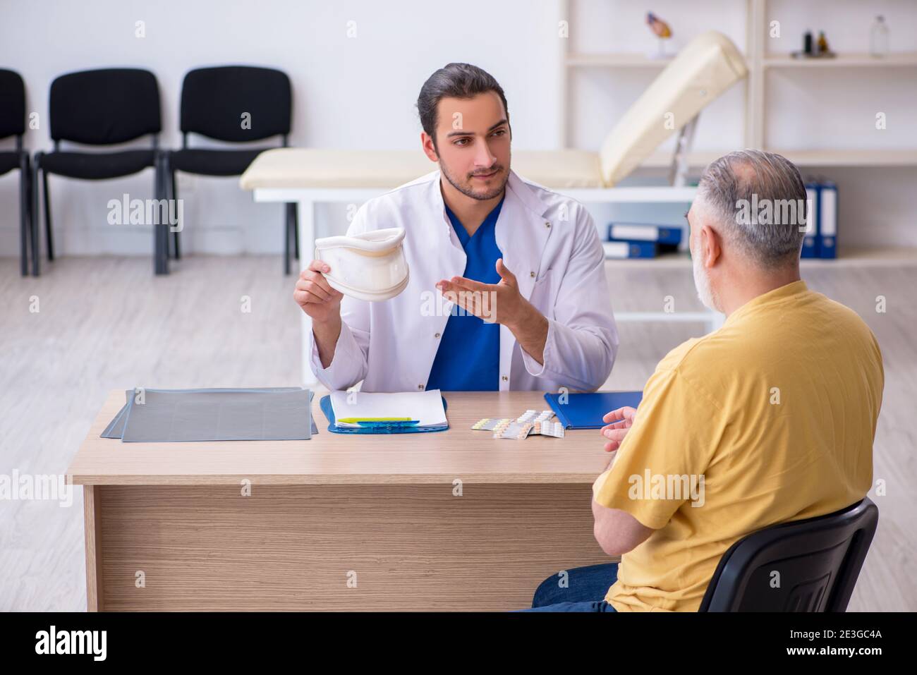 Alter Hals verletzten Mann besucht jungen Arzt Stockfoto