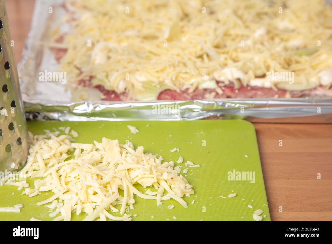 Backen Sie Fleisch im Ofen auf einem Backblech sind Fleischstücke gewürzt mit geriebenem Käse. Kochkonzept, Kochen,. Hochwertige Fotos Stockfoto