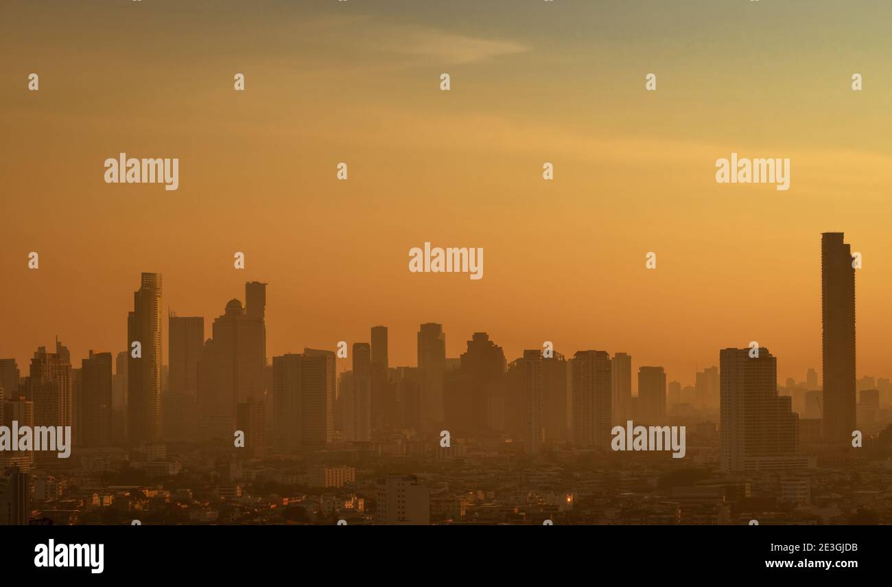 Luftverschmutzung. Smog und feiner Staub von pm2.5 bedeckt Stadt am Morgen mit orange Sonnenaufgangshimmel. Stadtbild mit verschmutzter Luft. Schmutzige Umgebung. Stadt Stockfoto