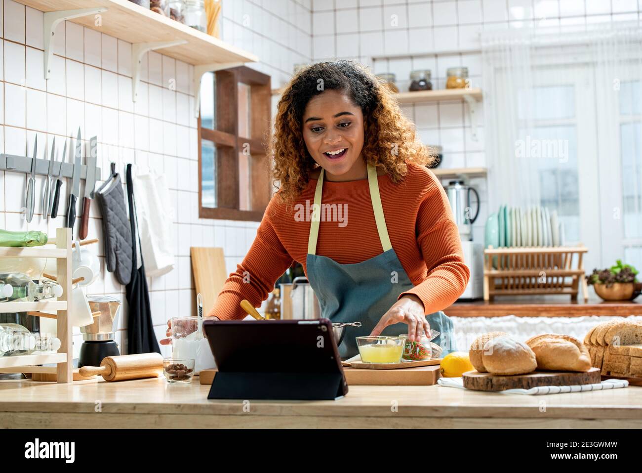 Junge Afican amerikanische Frau lernen Online-Kochkurs über Tablet Computer in der Küche zu Hause Stockfoto