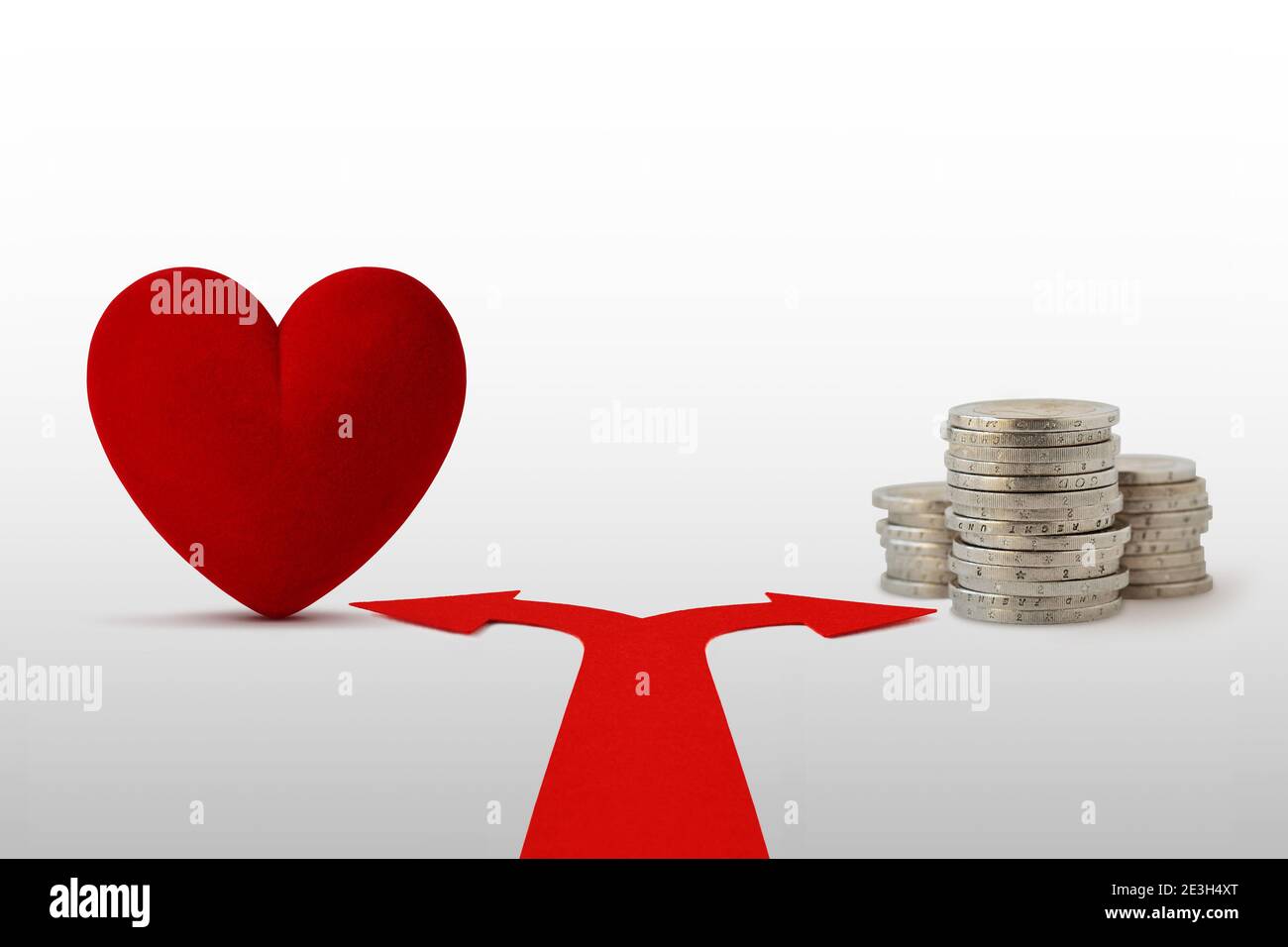 Zwei-Wege-Pfeile mit Herz und Münzen - Konzept Wahl zwischen Liebe und Geld Stockfoto