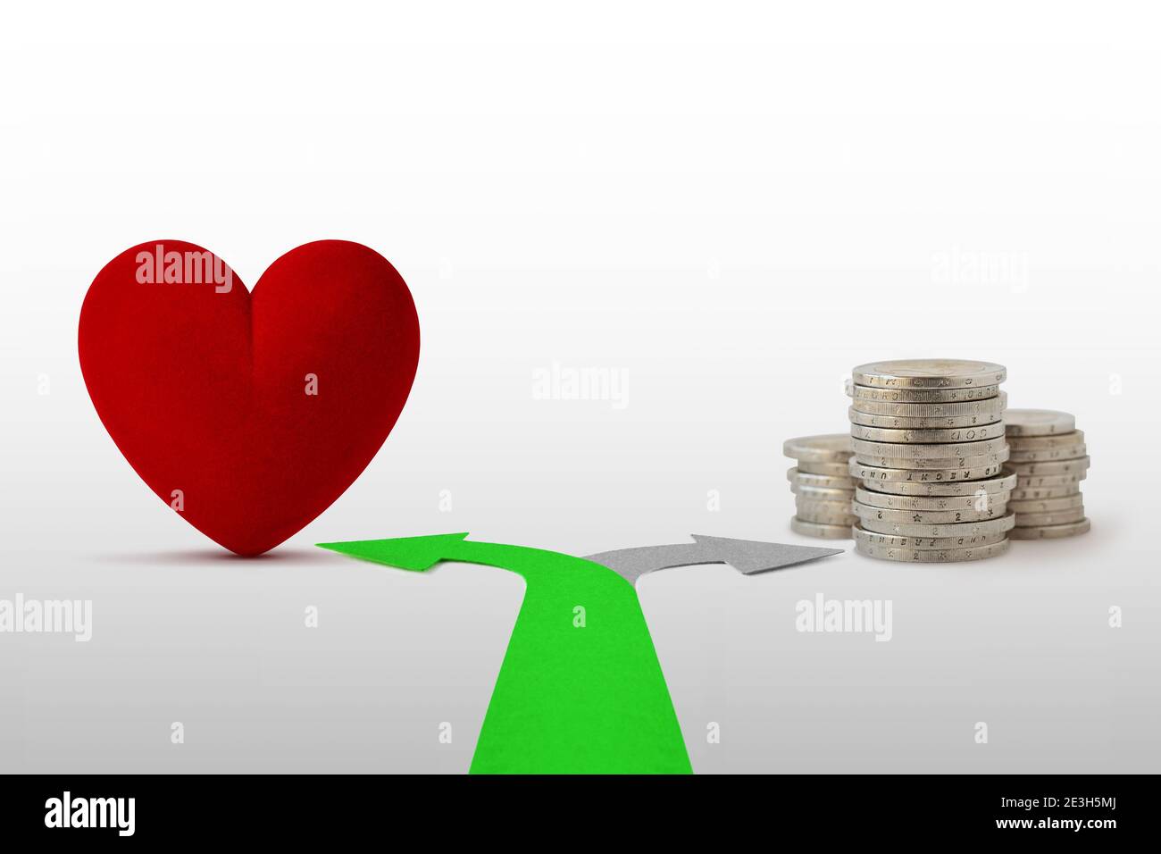 Zwei-Wege-Pfeile mit Herz und Münzen - Konzept Liebe statt Geld wählen Stockfoto
