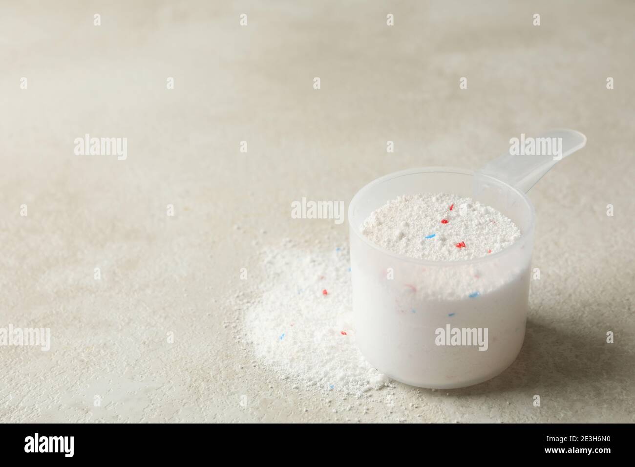Schaufel mit Waschpulver auf hellbeige strukturiertem Hintergrund Stockfoto