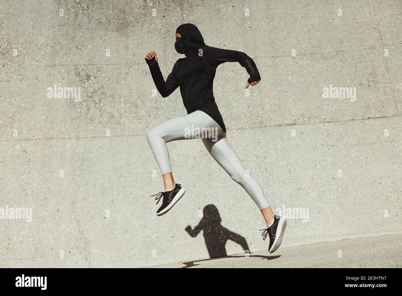 Frau in Sportbekleidung Sport im Freien. Frau beim Laufen und Springen in Sportkleidung. Stockfoto