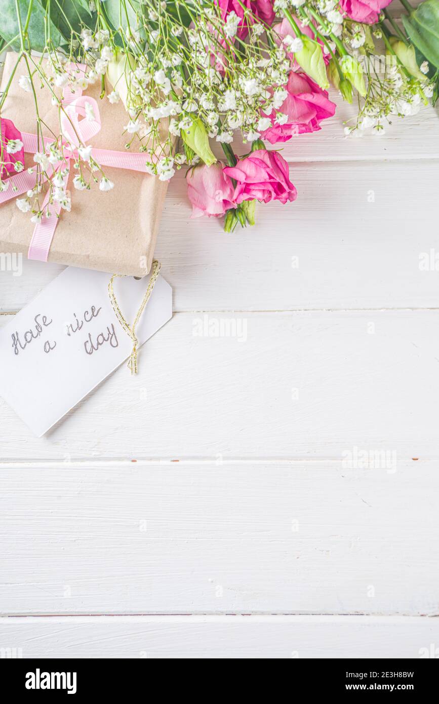 Blumenstrauß aus Frühling, Sommerblumen, Kaffeetasse und Noten Guten Morgen, haben Sie einen schönen Tag auf weißem Holztisch. Sommer Morgen schönes Frühstück, begrüßen Stockfoto