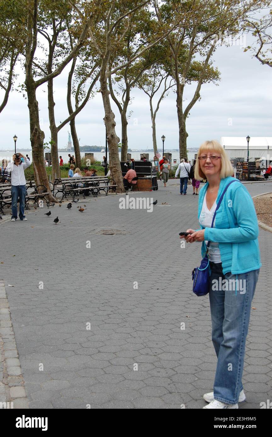 Freiheitsstatue und Küstenlinie in New York, USA, Touristenboote, Wassertouristen, Hudson River Person, blond aussehende Lady Trees, Baumbucht Stockfoto