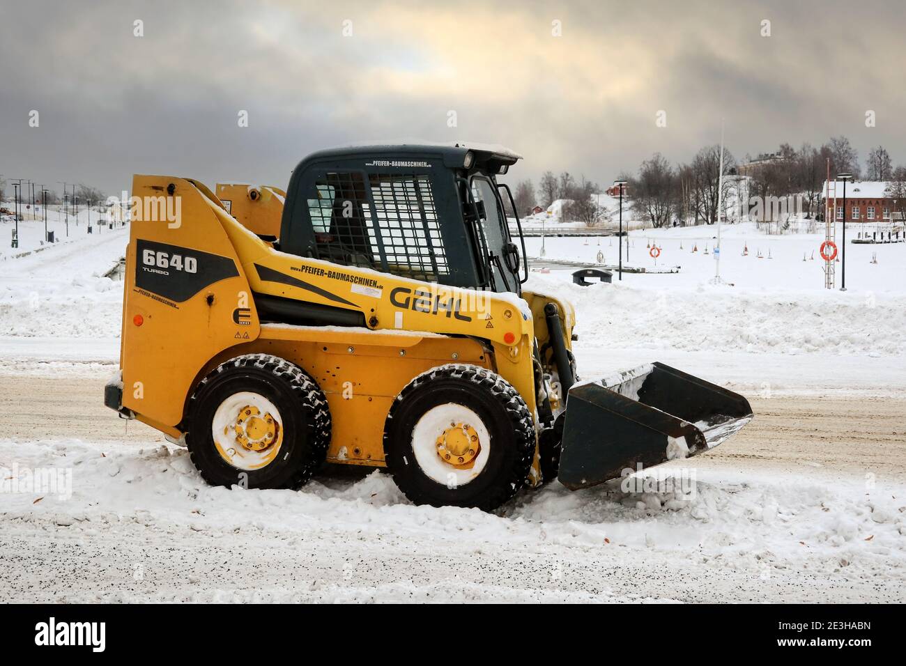 Gelber Gehl 6640 Kompaktlader zum Entfernen von Schnee in der Stadt geparkt an der Seite einer Straße am Meer. Helsinki, Finnland. Januar 18, 2021. Stockfoto