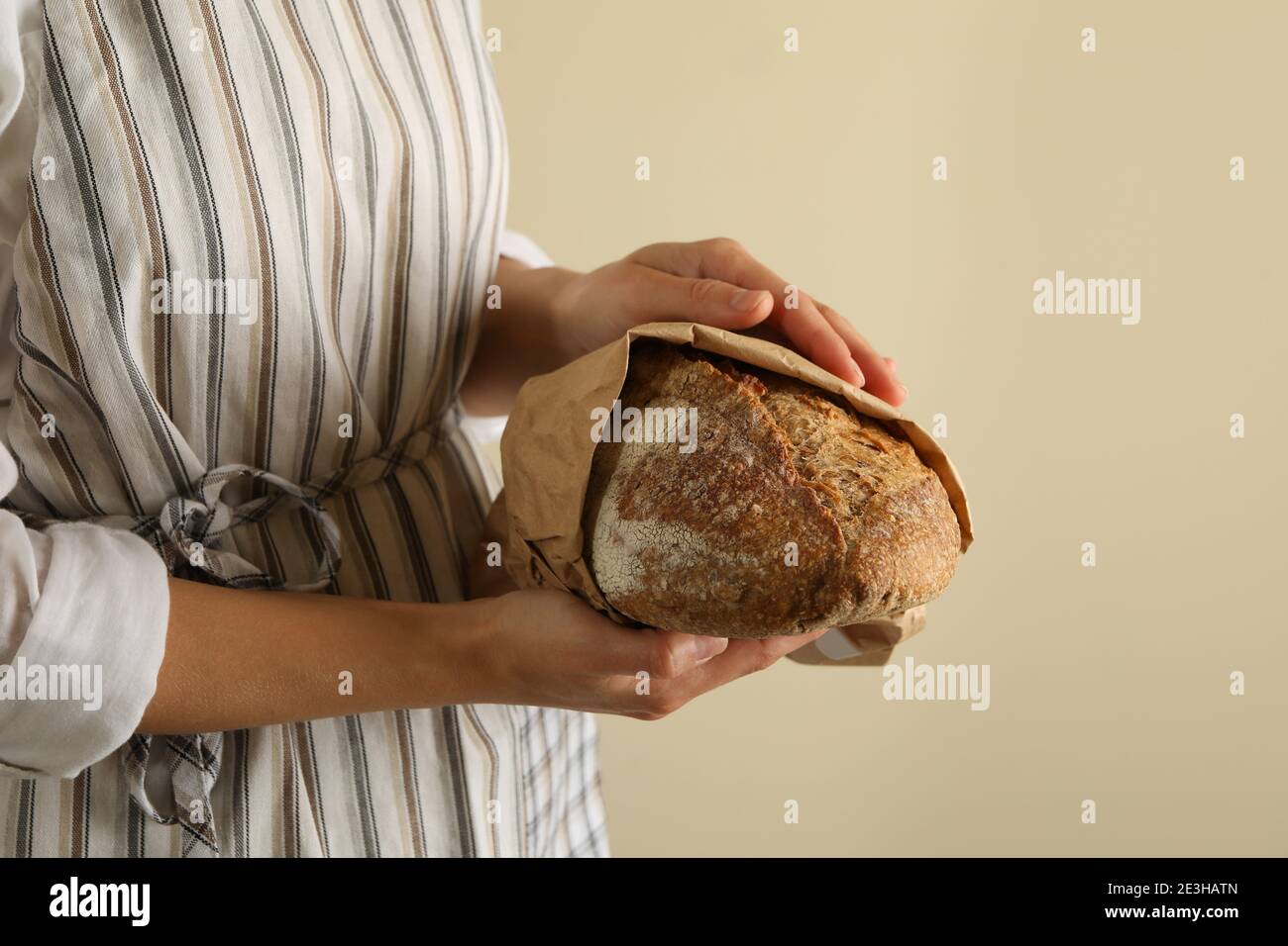 Frau in Schürze halten frisch gebackenes Brot Stockfoto