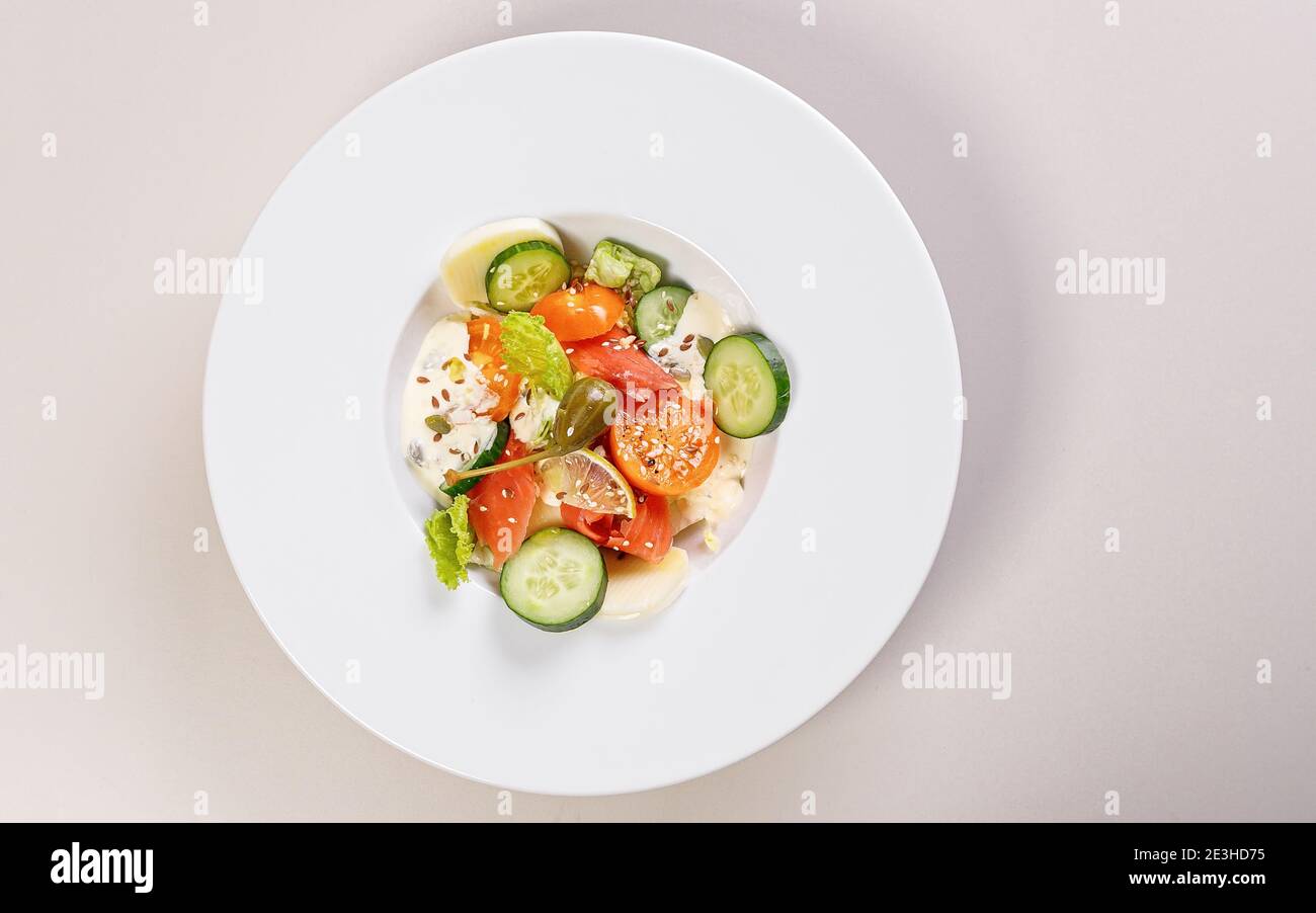 Schnelle und gesunde Lebensmittel Rezepte. Salat mit Lachs, Gemüse, Kräutern und Kapern auf weißem Teller. Mediterrane Gerichte Rezepte. Draufsicht. Speicherplatz kopieren Stockfoto