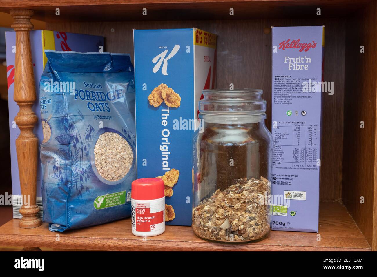 Eine Reihe Frühstückscerealien plus eine Flasche Vitamin D Pillen auf einem Regal in einer heimischen Küche in Oldham, Großbritannien. Stockfoto