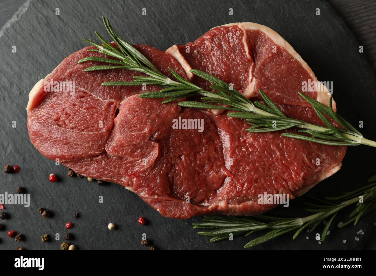 Tablett mit Steak Fleisch mit Kräutern und Gewürzen auf dunkel Holzhintergrund Stockfoto