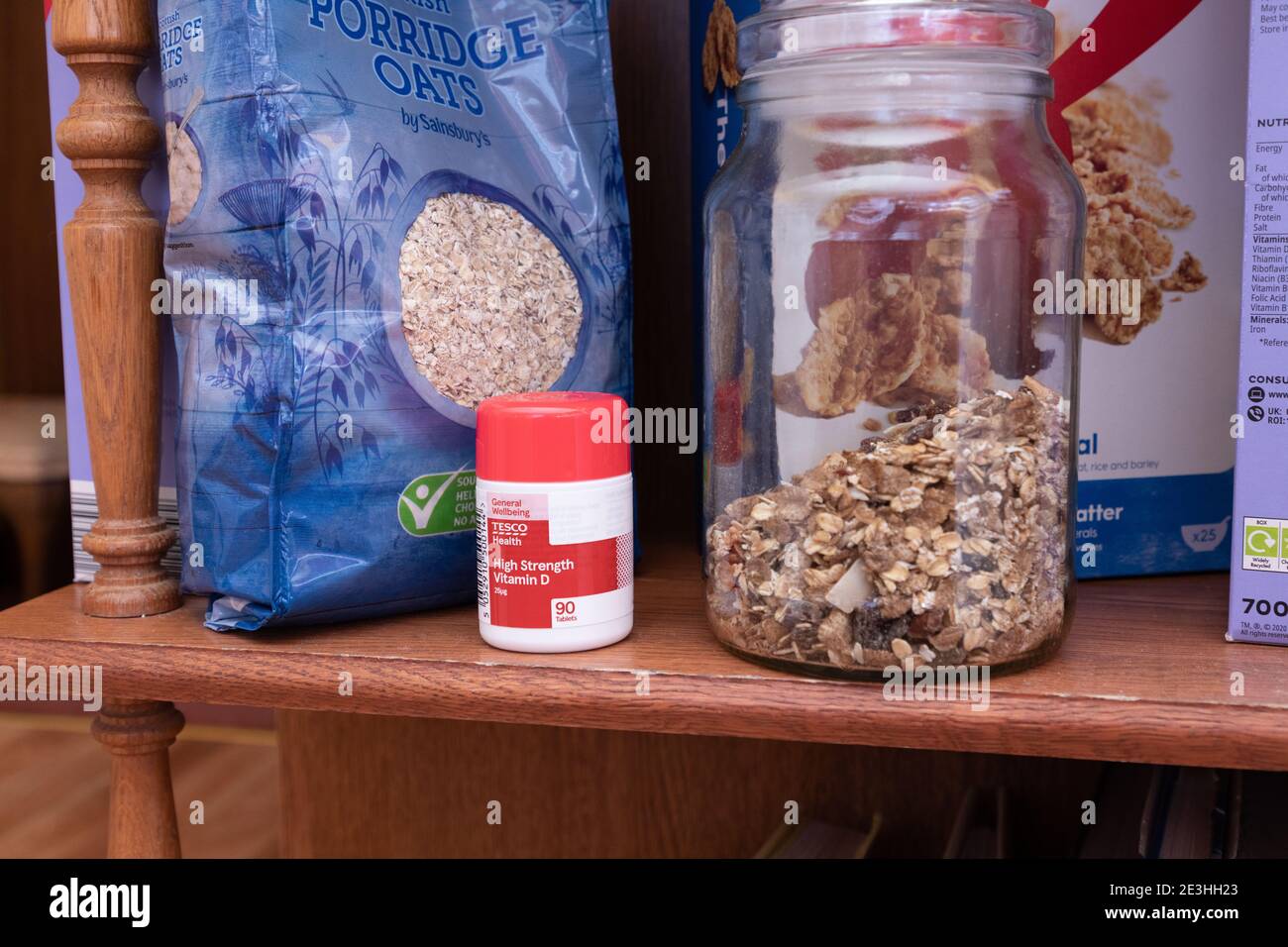 Eine Reihe Frühstückscerealien plus eine Flasche Vitamin D Pillen auf einem Regal in einer heimischen Küche in Oldham, Großbritannien. Stockfoto