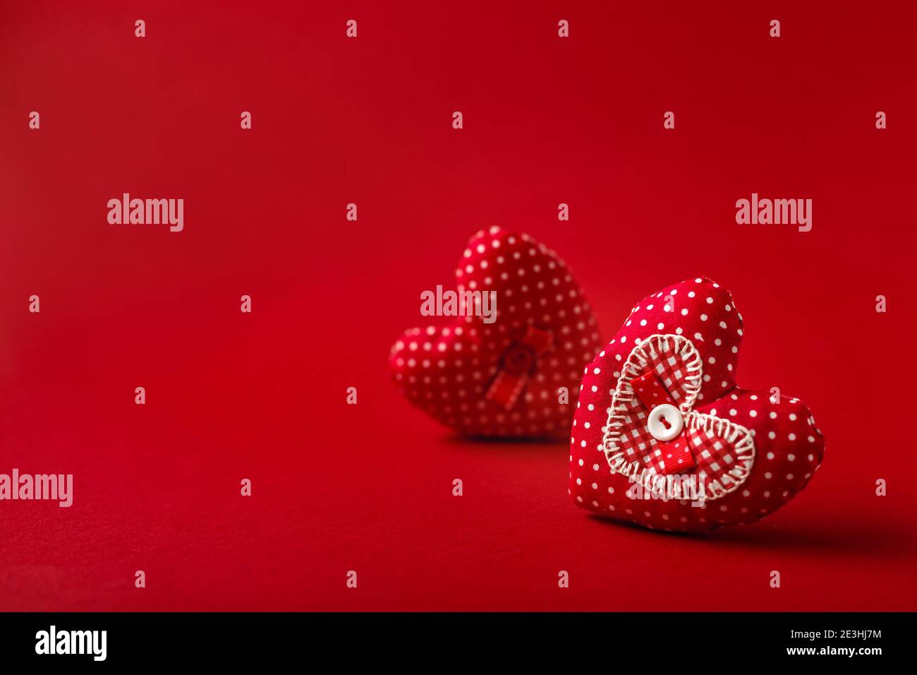 Handgemachte dekorative Stoffherzen für Valentinstag auf rotem Hintergrund Stockfoto