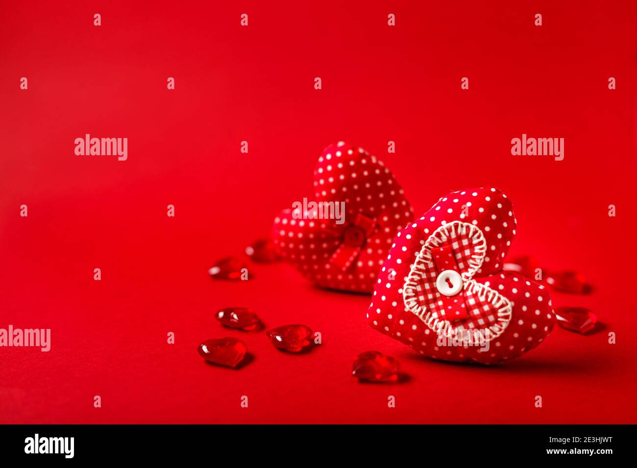 Handgemachte dekorative Stoffherzen für Valentinstag auf rotem Hintergrund Stockfoto