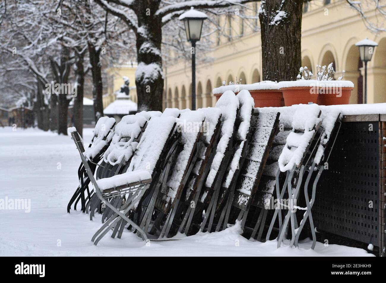 Die Sperrung wird bis zum 15. Februar 2021 verlängert. Themenbild: Winter in Zeiten der Coronavirus-Pandemie / Verlängerung der Sperrung bis 31. Januar 2021. Konsequenzen für die Gastronomie verschneite, gestapelte und gefaltete Stühle und Tische in einem Biergarten im Münchner Hofgarten am 6. Januar 2021. â Verwendung weltweit Stockfoto