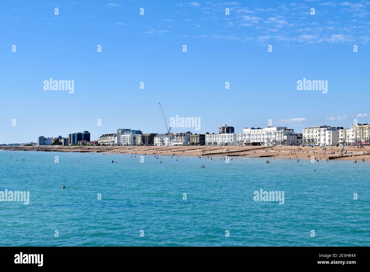 Worthing Beach UK, mit Menschen schwimmen im Meer Stockfoto