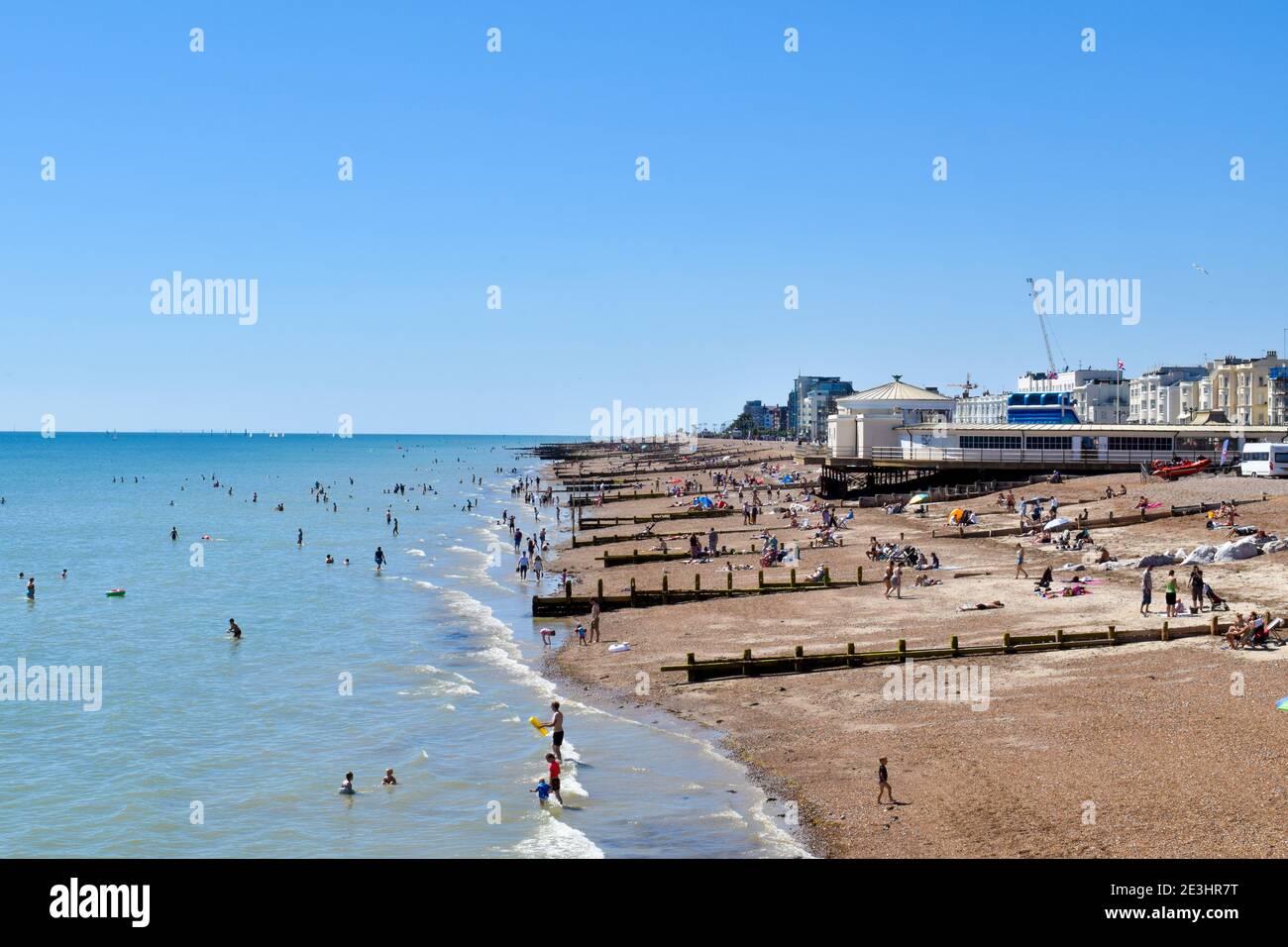 Blick auf Worthing Beach UK, mit Menschen schwimmen im Sommer Stockfoto