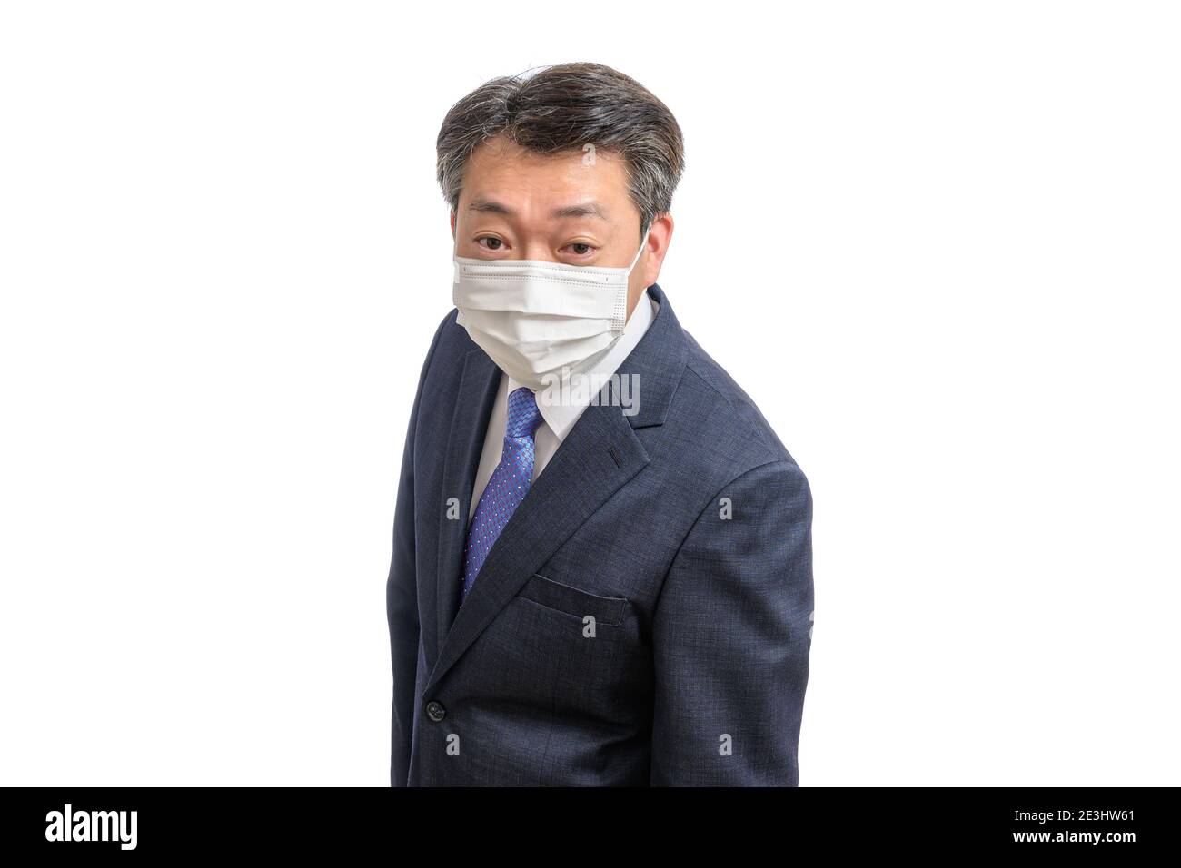 Porträt eines asiatischen Geschäftsmannes mittleren Alters mit weißer Gesichtsmaske. Weißer Hintergrund. Covid19, Gesundheit und Geschäftskonzepte. Stockfoto