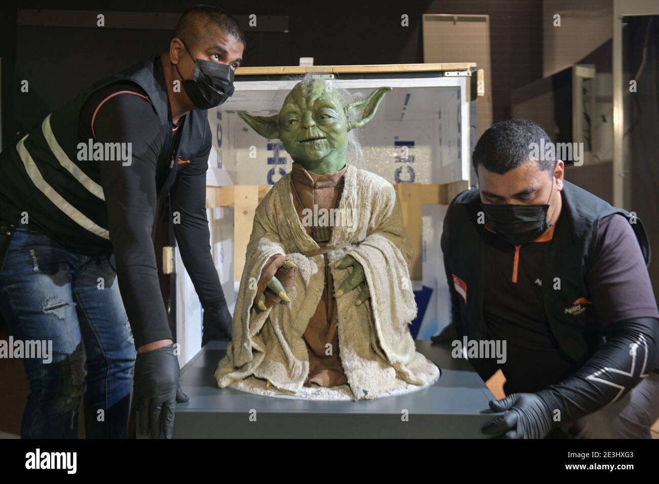 Singapur. Januar 2021. Arbeiter bewegen die lebensgroße Figur der Star Wars-Figur "Yoda", um sie am 19. Januar 2021 in der Ausstellung "Star Wars Identities: The Exhibition" im Kunstwissenschaftlichen Museum in Singapur zu zeigen. Die Ausstellung findet vom 30. Januar bis 13. Juni im ArtScience Museum statt. Kredit: Dann Chih Wey/Xinhua/Alamy Live Nachrichten Stockfoto