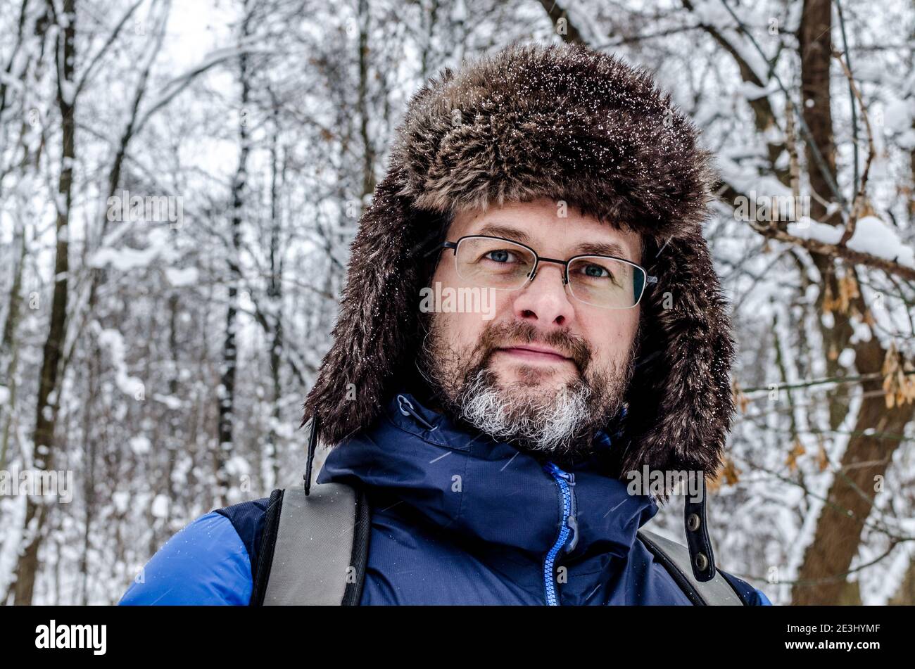 Portrait Nahaufnahme eines mddle gealterten Mannes mit grau Bart in einem verschneiten Winterwald Stockfoto