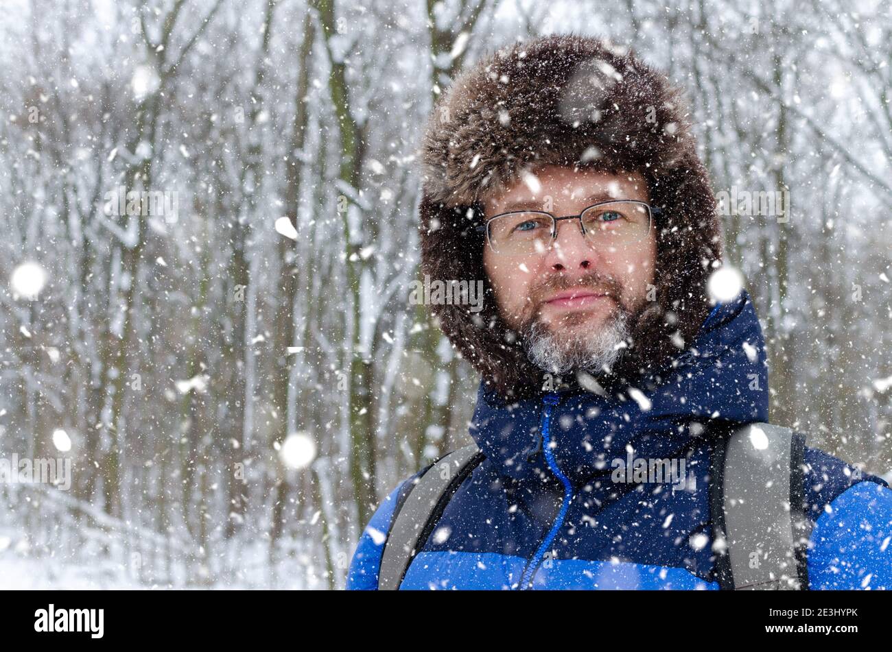 Portrait Nahaufnahme eines mddle gealterten Mannes mit grau Bart in einem verschneiten Winterwald Stockfoto