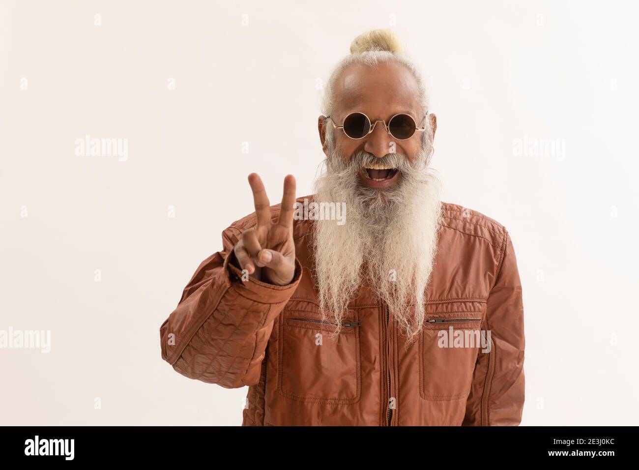 EIN STILVOLLER ALTER MANN GESTIKULIERT FRÖHLICH VOR DER KAMERA Stockfoto