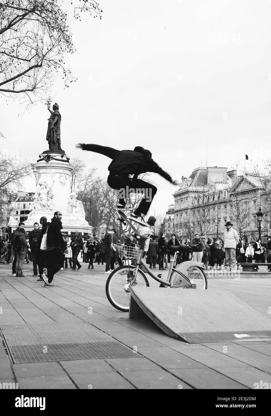 PARIS, FRANKREICH - 28. JANUAR 2017: Skateboarder machen Akrobatik und springen über Barriere und Fahrrad (verschwommene Bewegung) am Place de la Republique. Stat Stockfoto