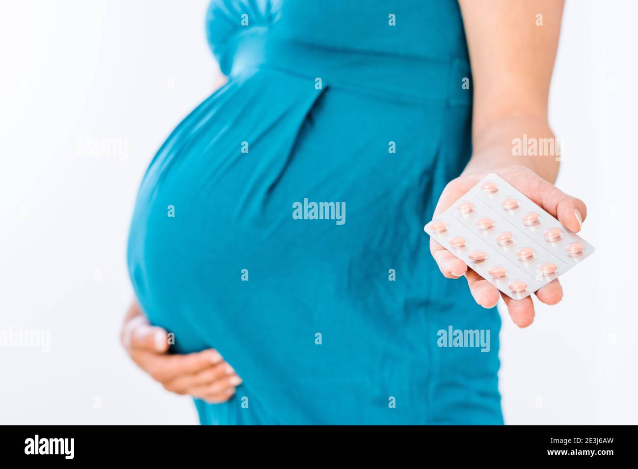 Schwangere Frau hält Nahrungsergänzungsmittel in der Hand Stockfoto