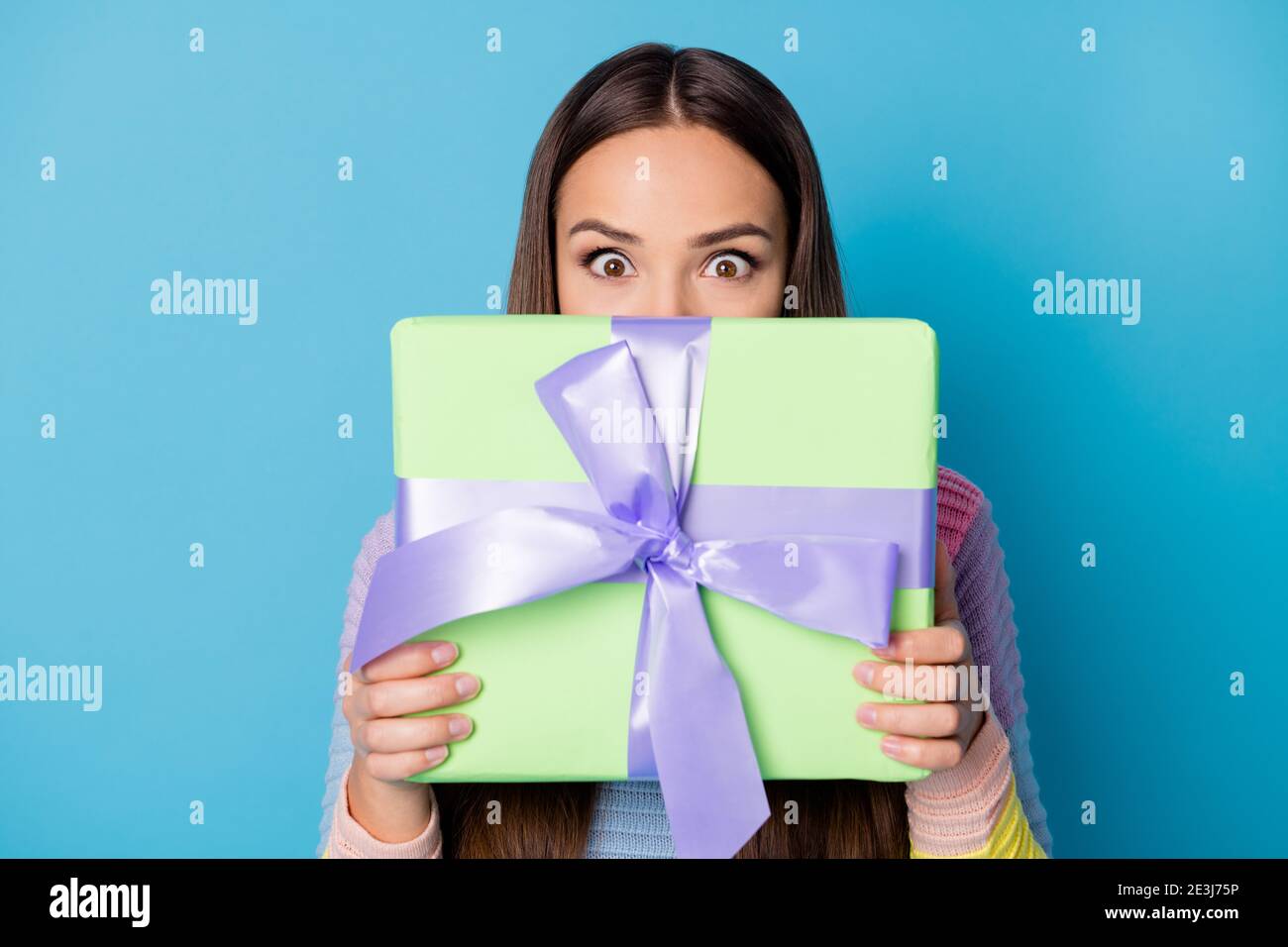 Foto von staunte Mädchen close face Geschenkbox erhalten 14-februar 8-märz tragen Pullover isoliert blauen Hintergrund Stockfoto